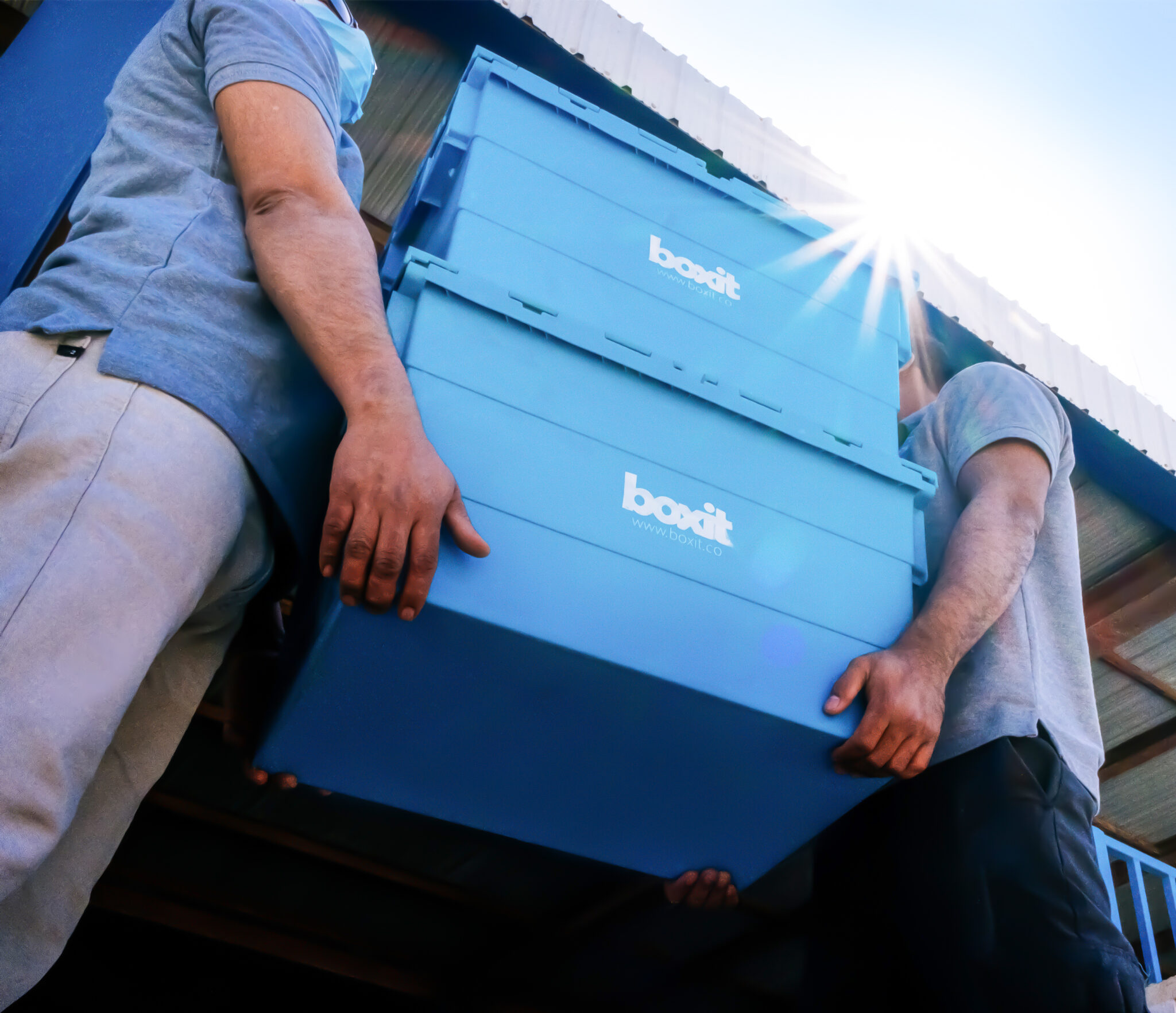 Boxit team carrying blue storage boxes